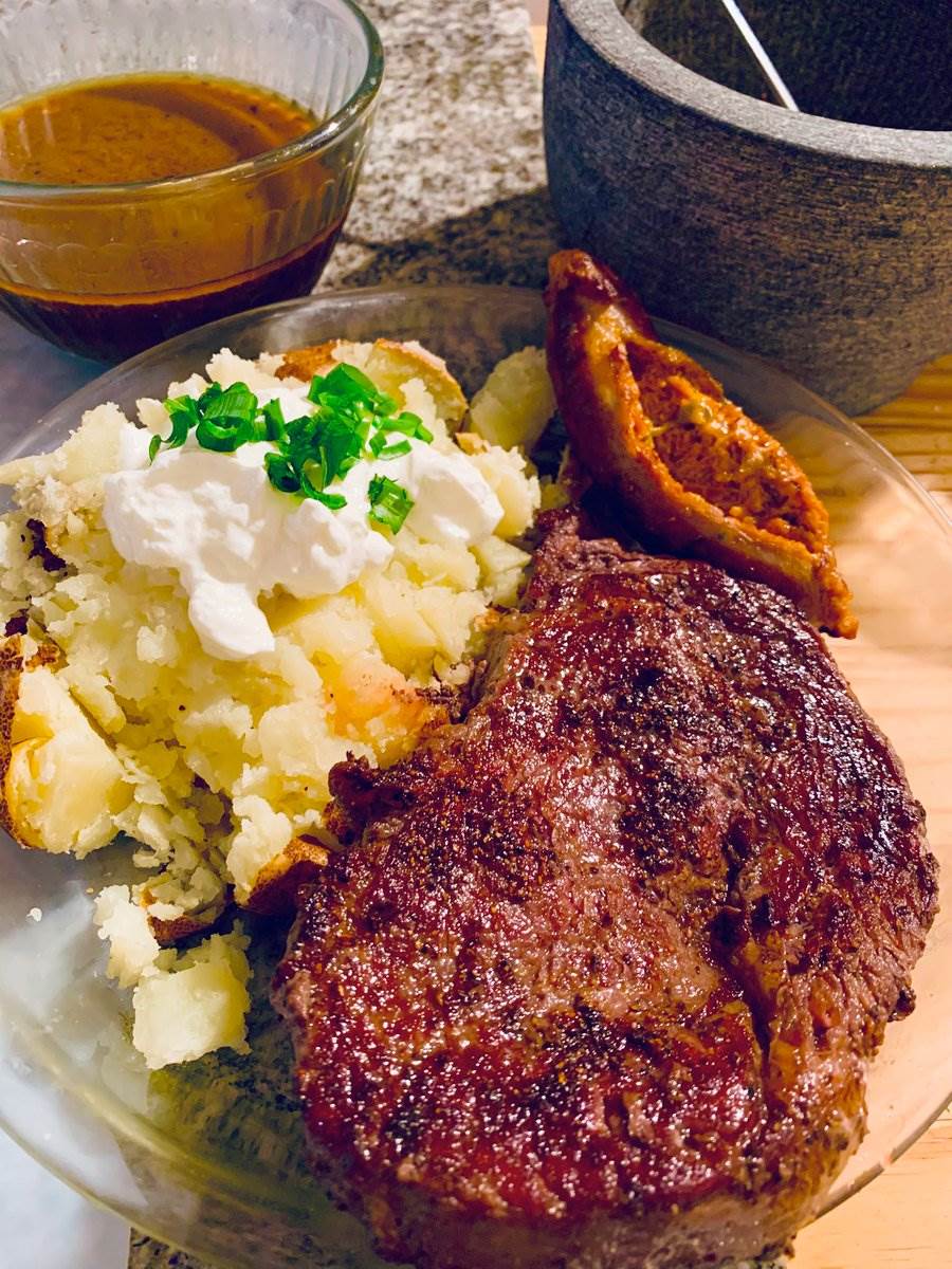Ribeye with a loaded baked potato and crisp skin, 2026 — photograph by Ray Patrick