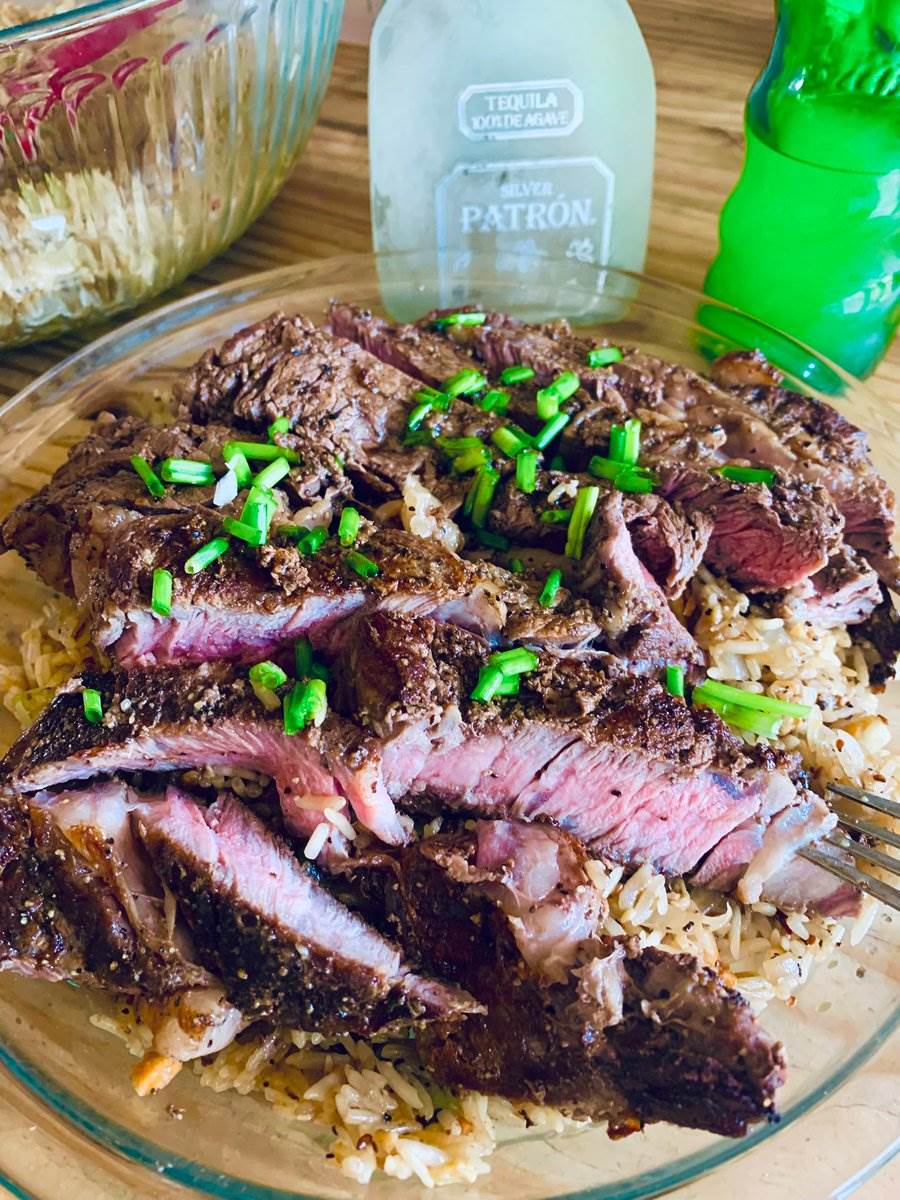 Sliced ribeye over pork fried rice with chives, 2026 — photograph by Ray Patrick